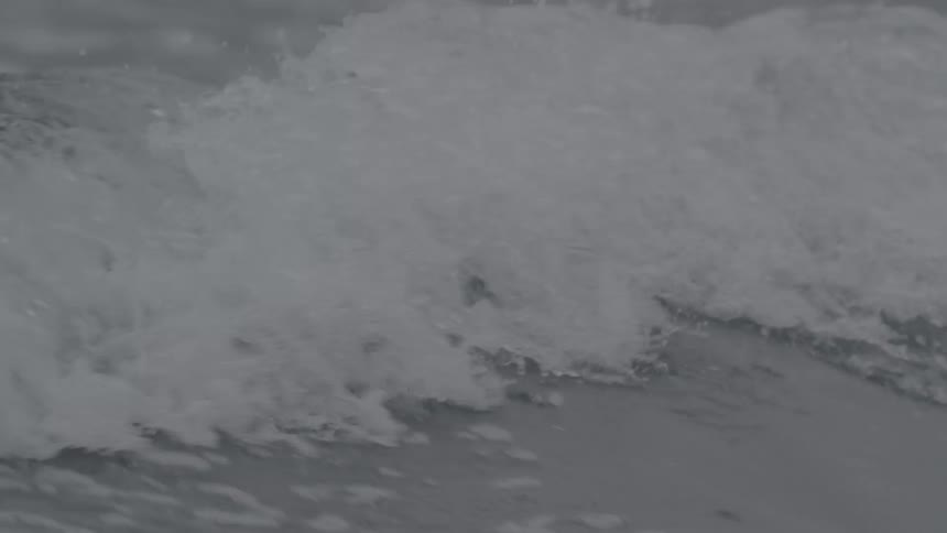 Waves splash as they roll into shore and over the beach