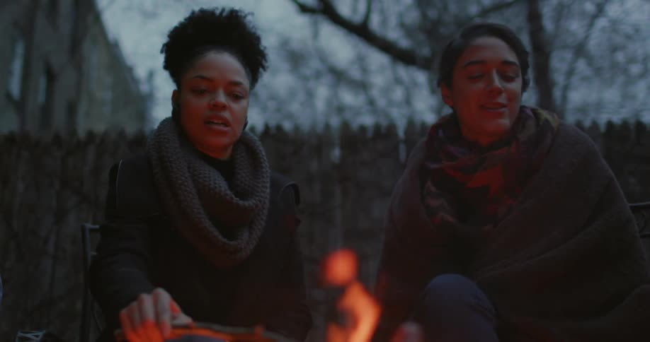 People roasting something over an open fire