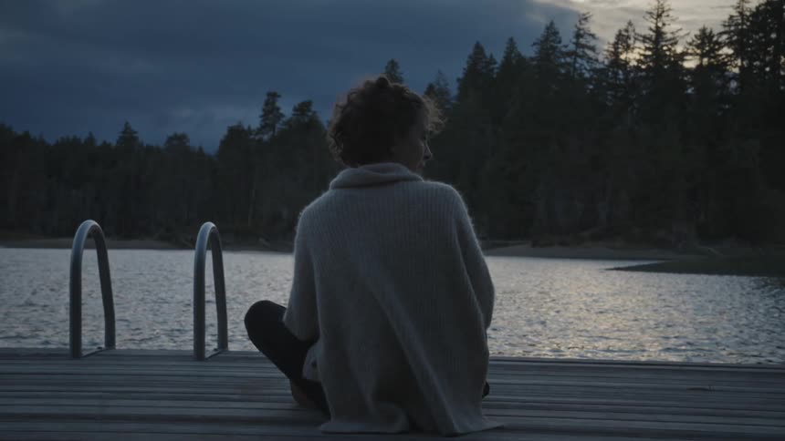 Woman sitting at lake by the lake
