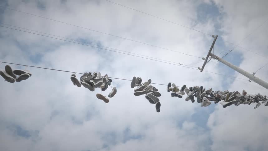 Shoes hanging from the wire of an electricity pole