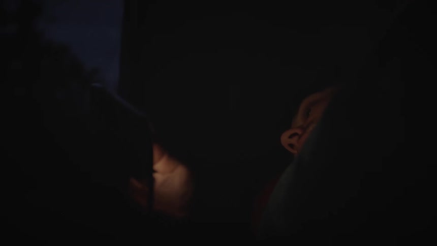 Portrait of a person lying down and using a cellphone at night