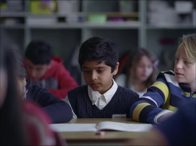 Two pupils talking during an exam at school