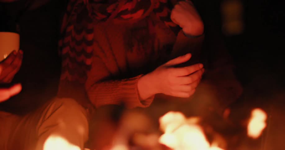 People sitting near a campfire at night