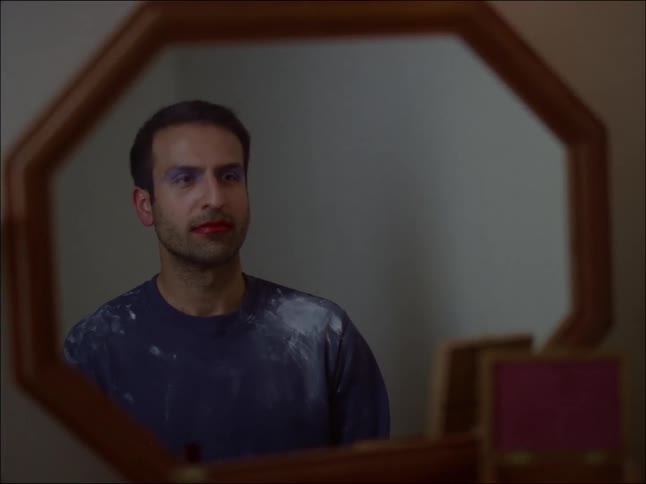 An adult man looking at the mirror from his room