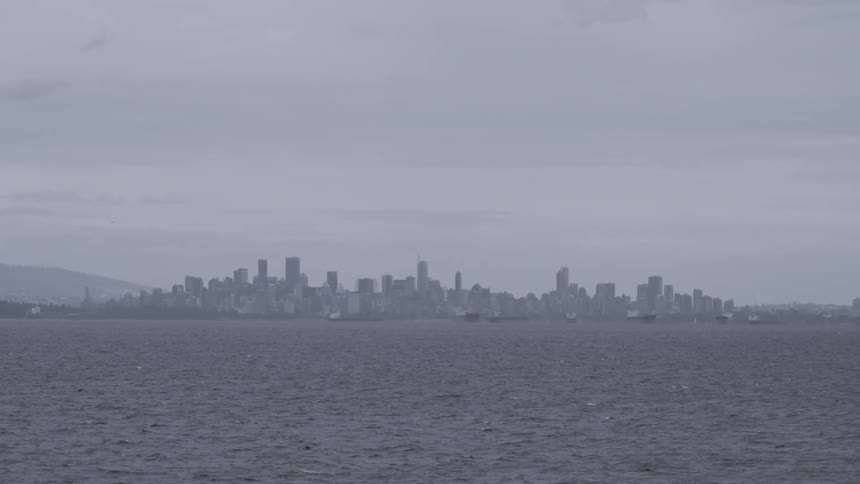 Panoramic view of sky scrapers in Vancouver by the sea on a cloudy day