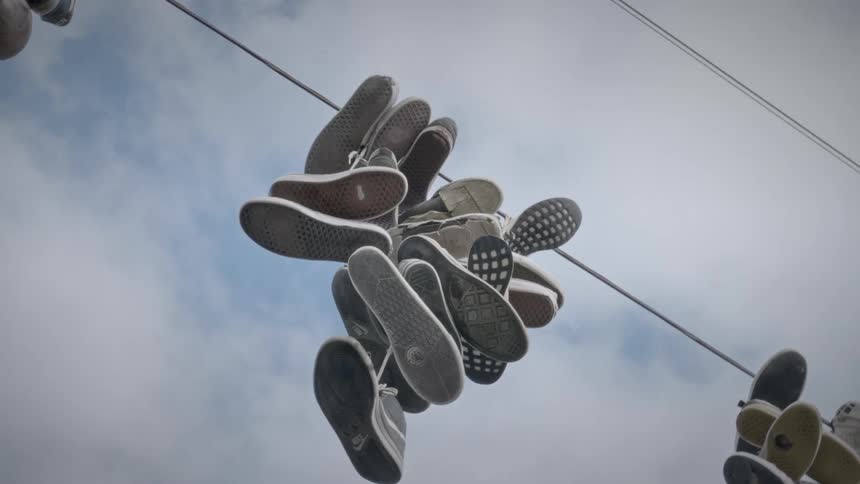 Groups of sports shoes hanging from a clothes line