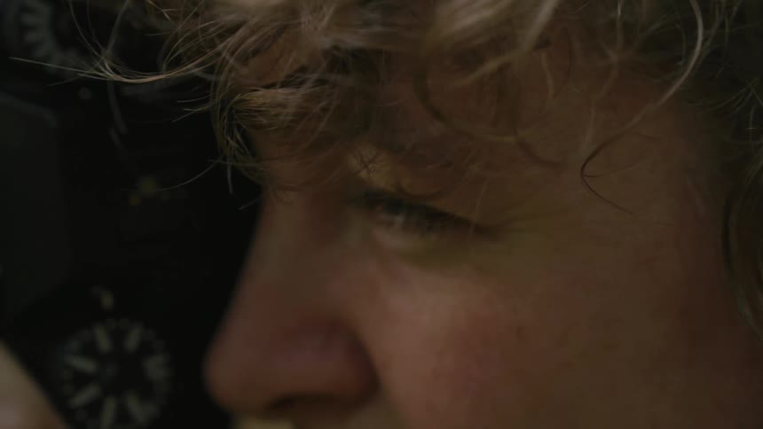 A blond boy or girl is taking photos looking through the view finder
