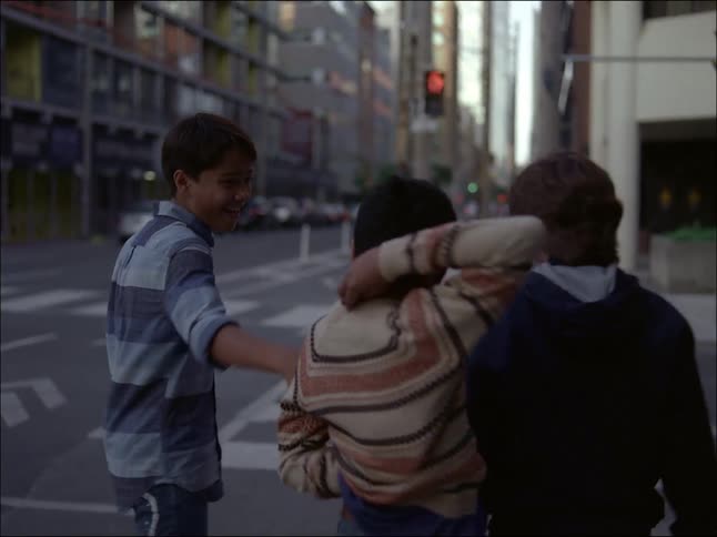 Children running down the street and playing one another in the city