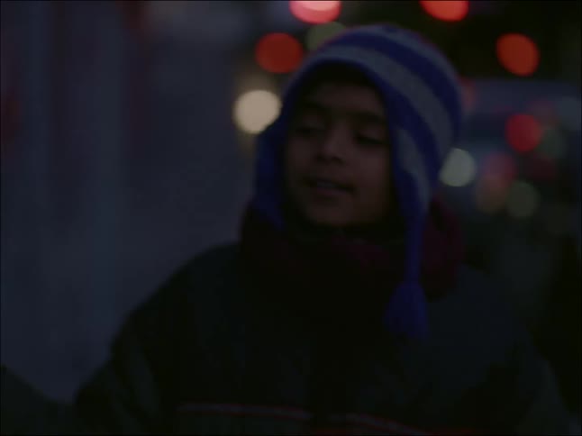 A small boy in warm clothes runs down the street