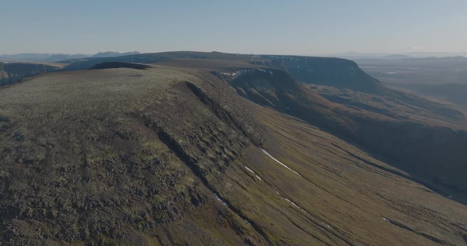 Aerial view of the panoramic landscape of a mountain plateau with patches of snow