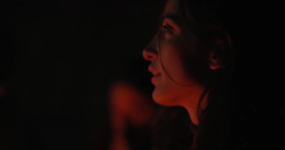 Two women sitting by a campfire at night
