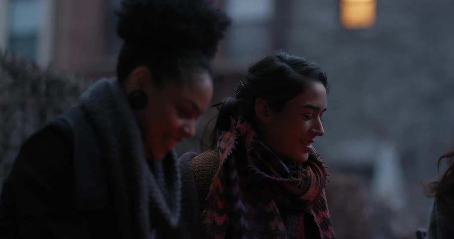 Two women stand outside by a building