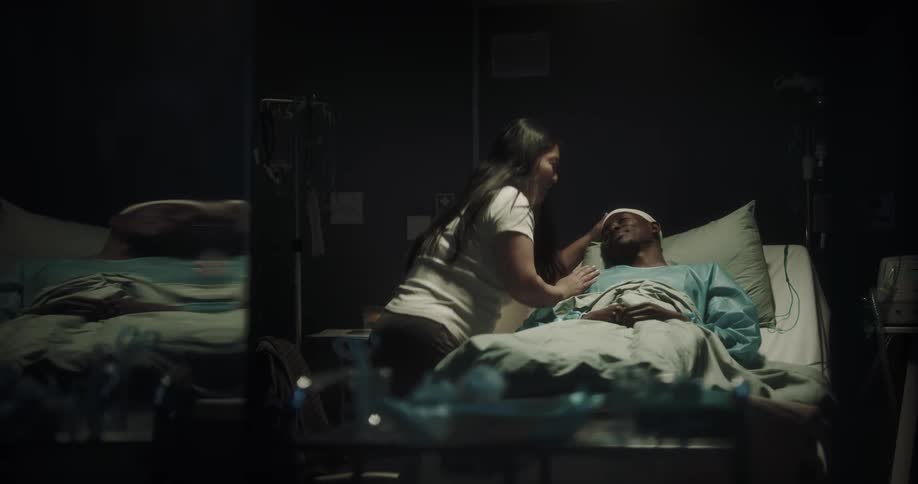 A woman talks with a patient in the hospital
