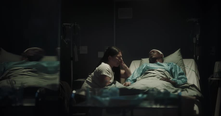 A woman cries over the patient in bed