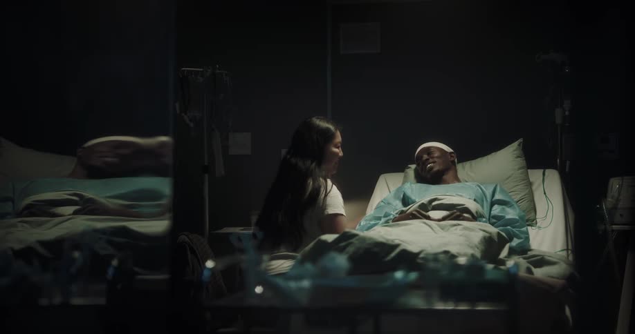 Woman arrives to visit patient lying in hospital bed