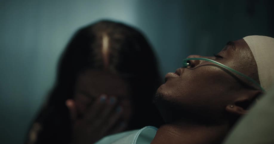 A woman crying by the side of her husband who is hospitalized