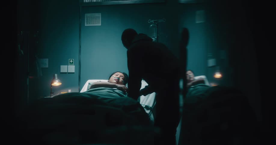 A visitor walks up to the patient in bed