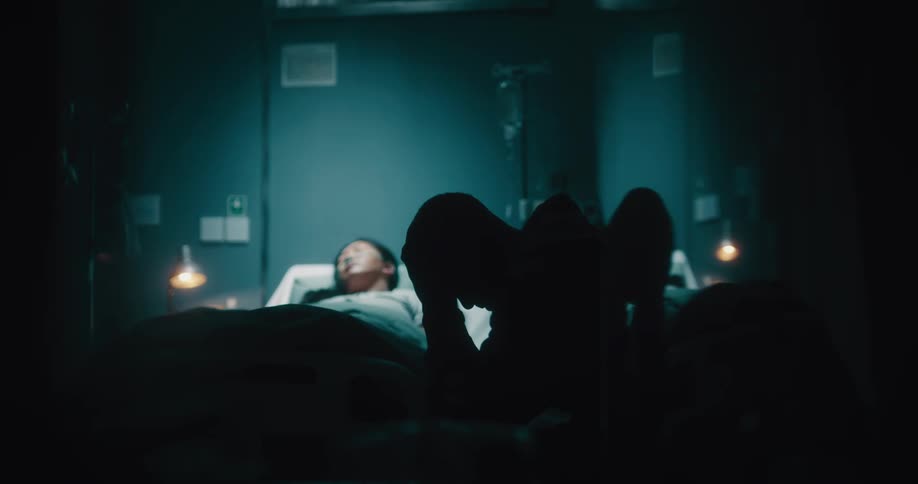 Sad man sitting next to his wife on a hospital stretcher