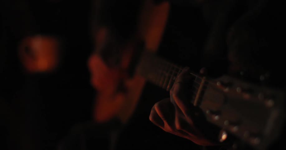 A person taps a guitar and beings playing