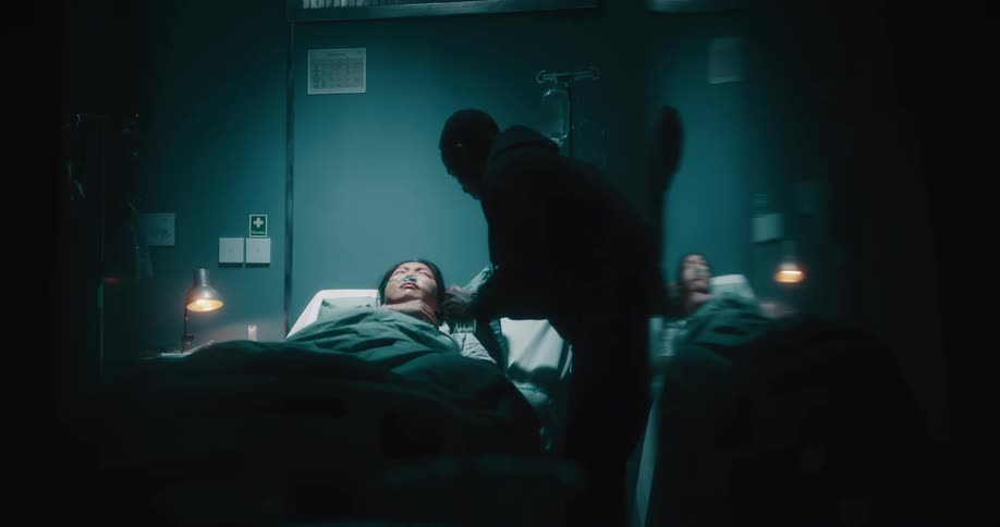 A man keeping company with a woman who is lying in a hospital bed