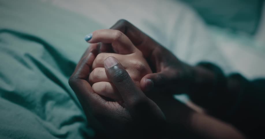 Closeup of the hands of two people interlocked
