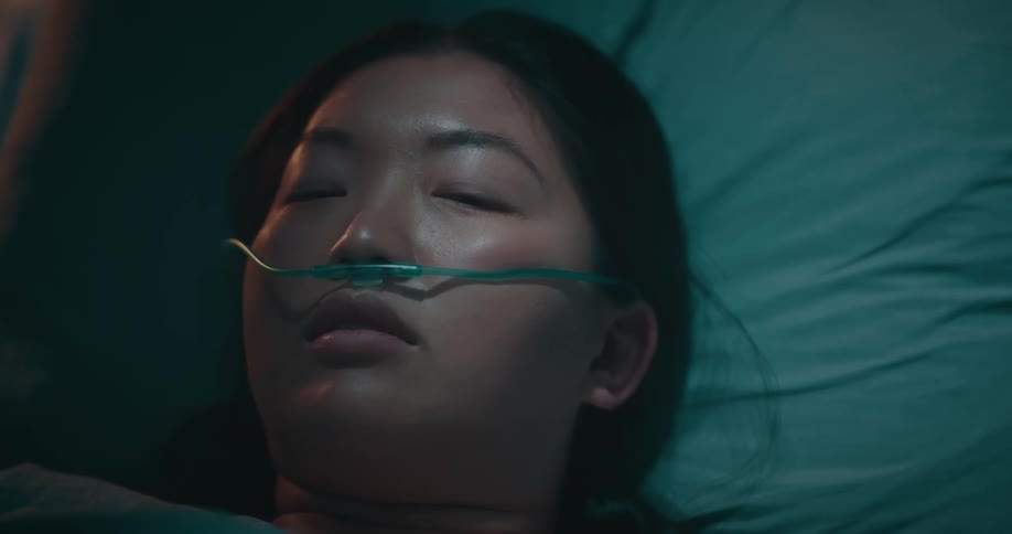 Closeup of a drowsy woman lying in a hospital bed
