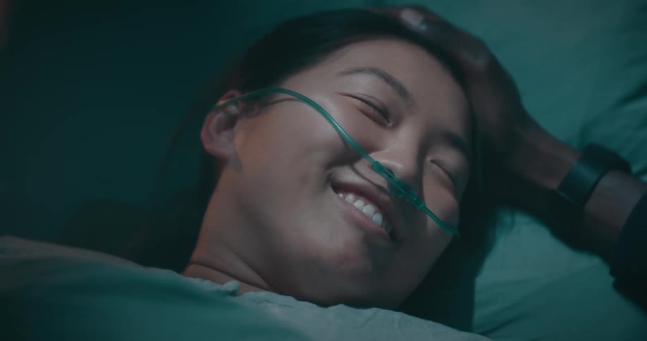 Portrait of a woman lying on a hospital stretcher having a conversation with a smiling person