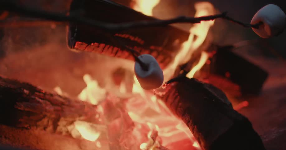 Several marshmallows on a stick roast over a fire