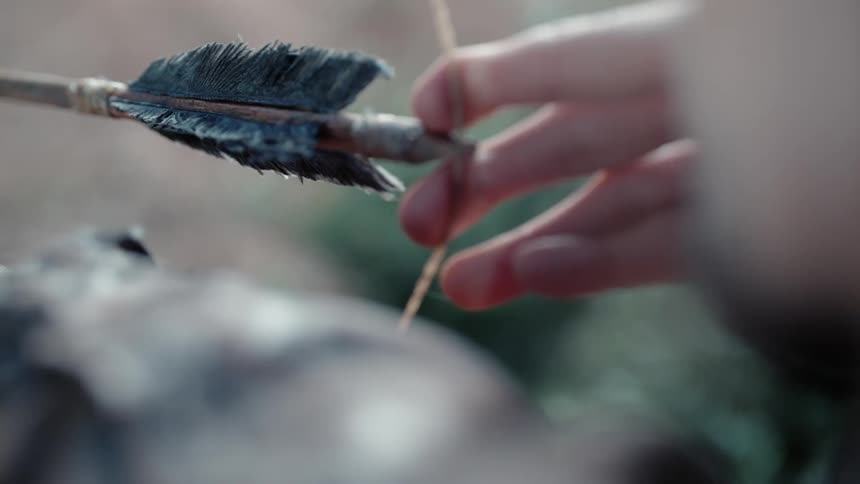 Person has arrow pulled back in a bow and releases it