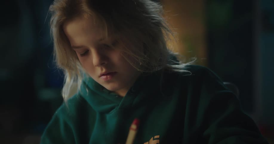 Portrait of a young girl drawing in a room