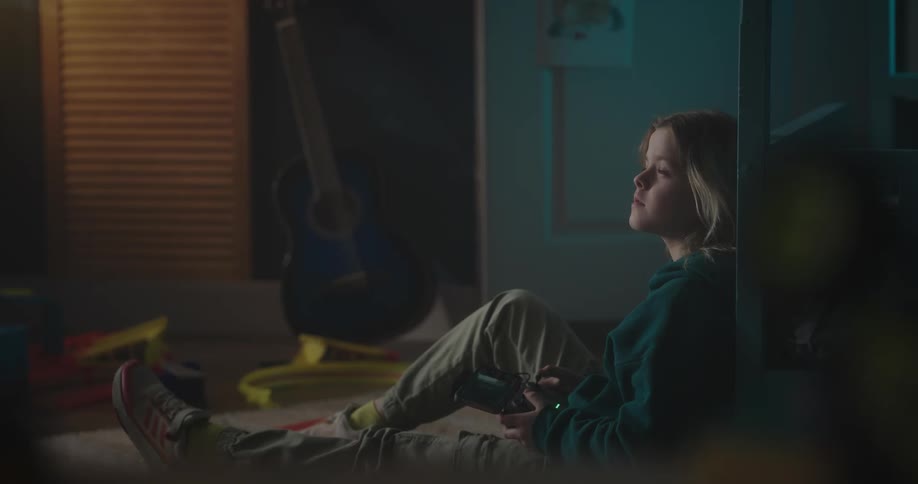 A child sitting on the ground driving a drone