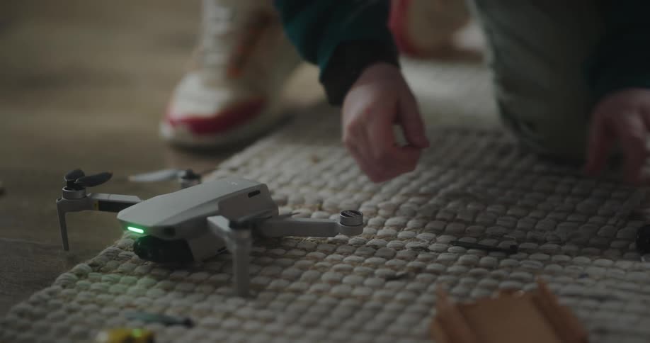 A child repairing a drone on the carpet