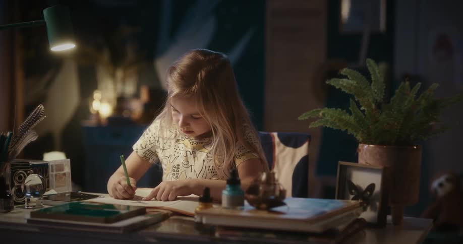 A young girl writes on a page with a pencil before looking up and posing