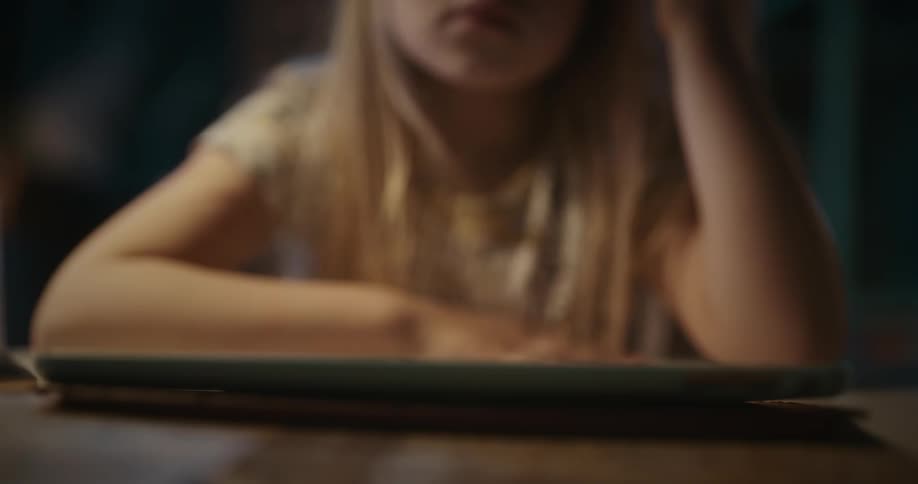 Bored girl taps on a tablet with her fingers
