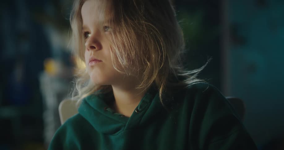 A young girl drawing with a pencil with a pause to think