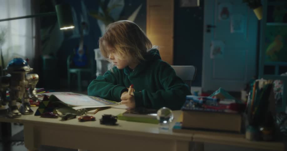 Blonde girl with a green hoodie writes in a notebook in her room