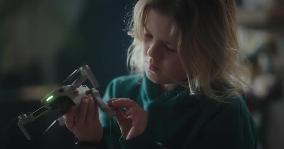 A female child playing with an electronic toy indoor