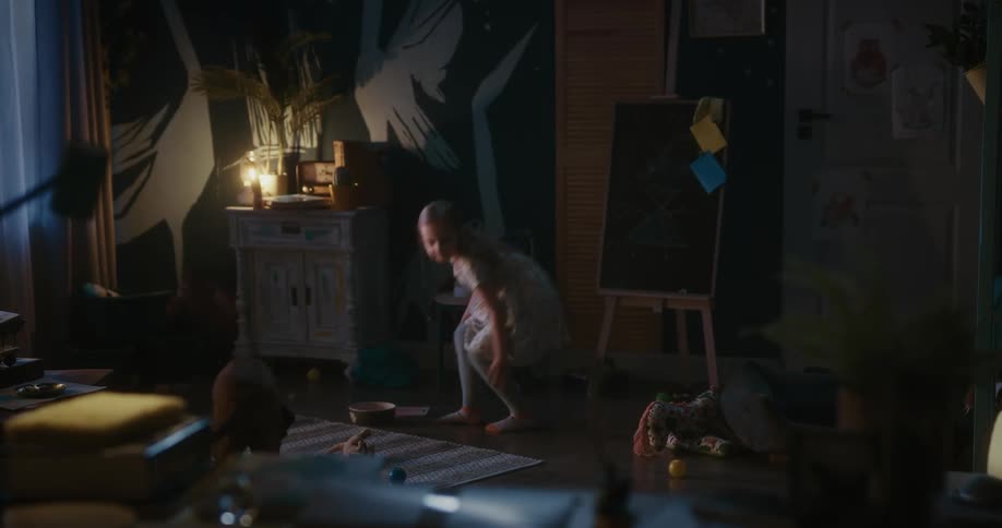 Girl indoors placing a bowl of food for her dog which then approaches the bowl