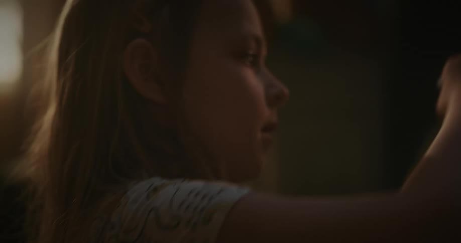 Girl drawing with chalk on a blackboard in a dimly lit room