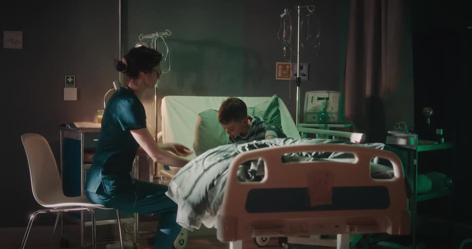 A nurse taking care of her patient in a hospital bed