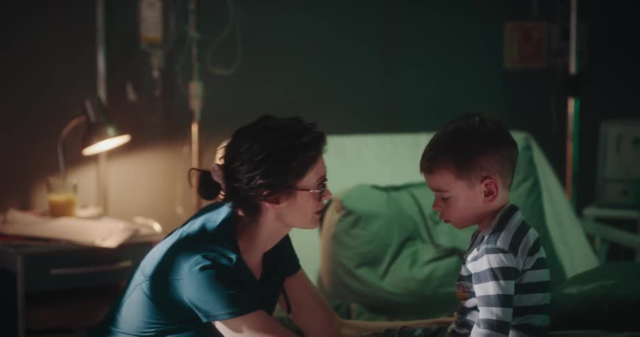 Nurse helping a sleepy child to stand up