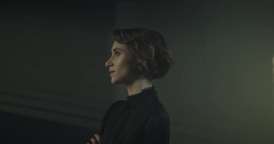 Light shines through opening onto womanstanding in dark area