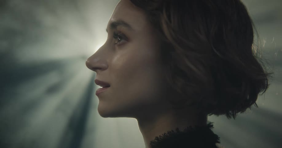 Face of a woman in front of a spotlight