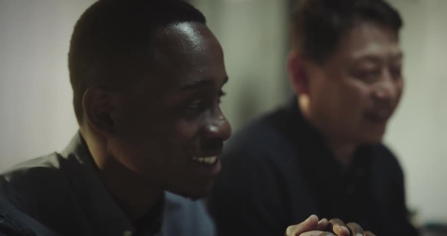 Portrait of a man shaking hands with another person and having a smiling conversation