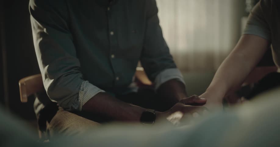Man holding hands with a woman inside a room