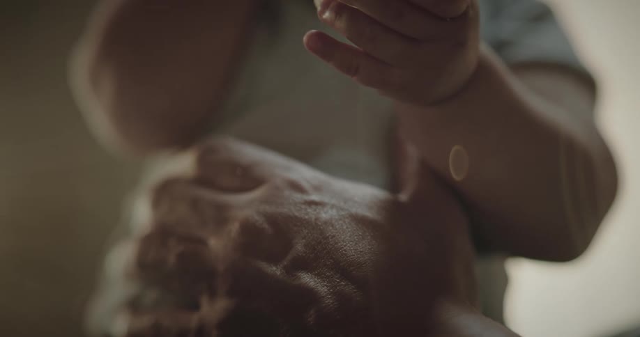 Baby held by a woman with both hands indoor