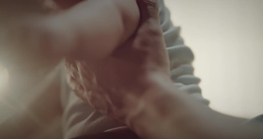 Closeup of a fathers hands holding his baby