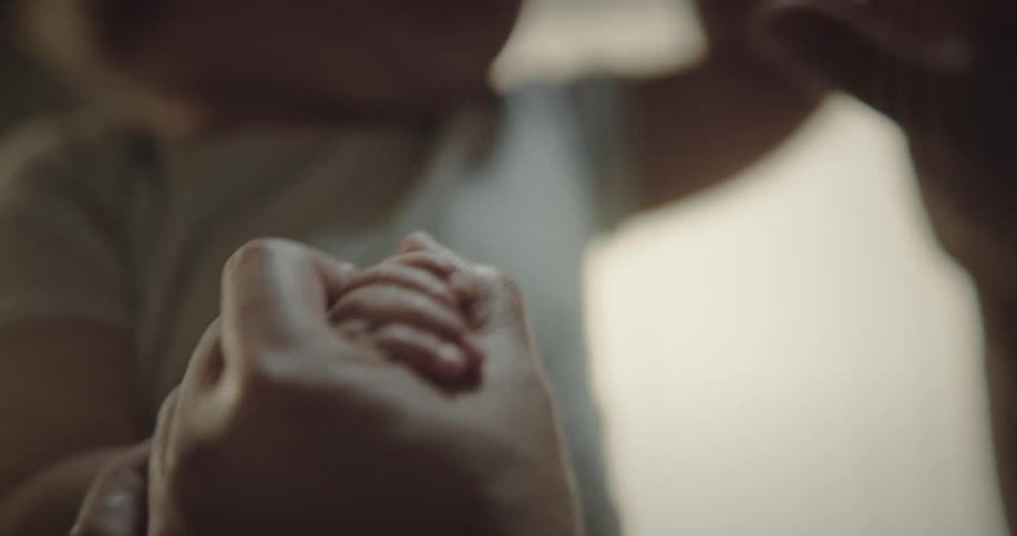 Arm of a person trying to feed a baby