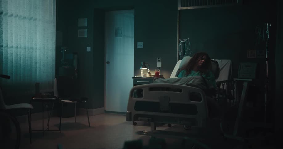 A young lady sleeping on her bed in her room with low light