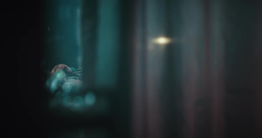 Hand of a patient resting on a hospial bed behind a curtain